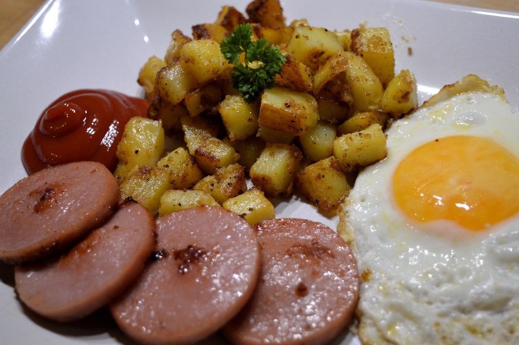 Falukorv och potatis med ketchup och stekt ägg.