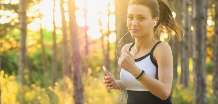Snygg indisk kvinna springer ute i en skog.