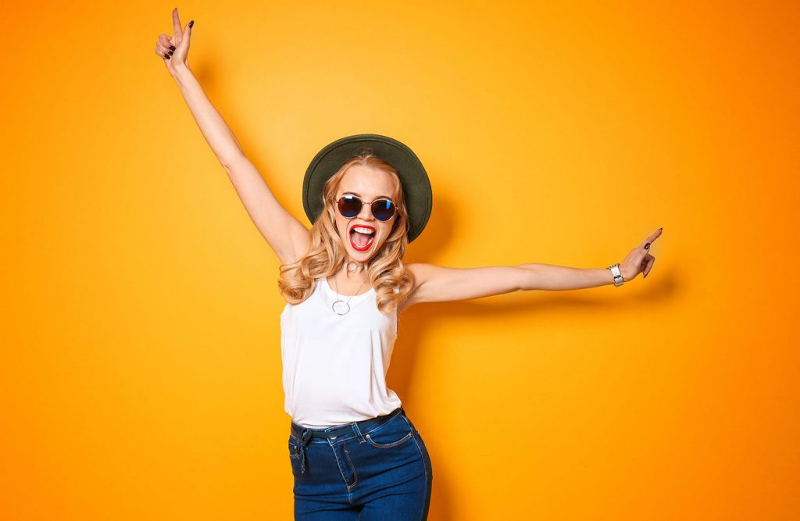 Fint leende av en glad vacker kvinna. Gul bakgrund.