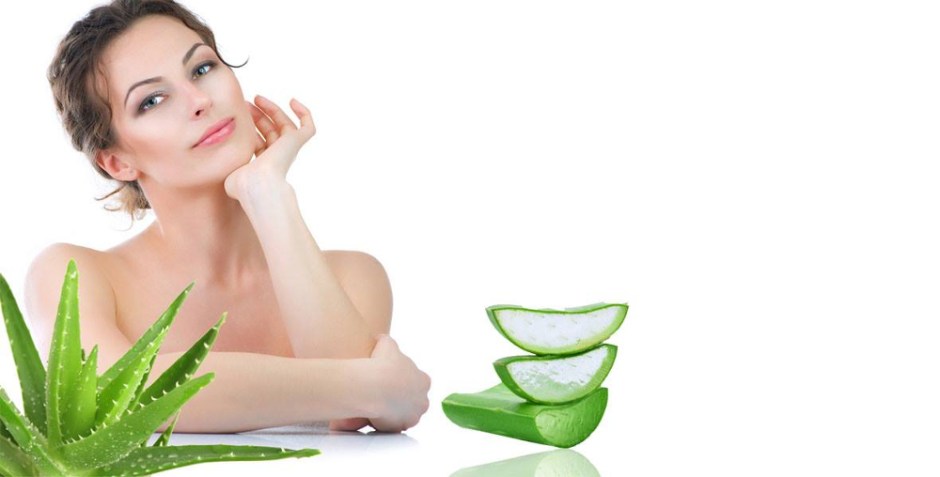 Vacker kvinna sitter med aloe vera plantor