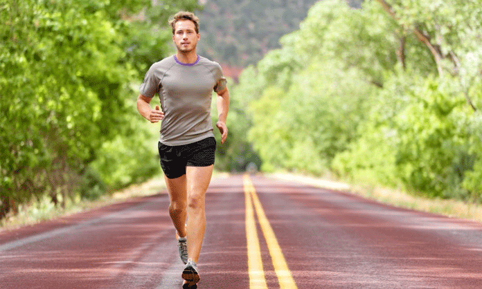 Frisk man ute och springer på vägen.