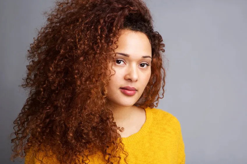Söt tjej med tjockt vackert krulligt hår.